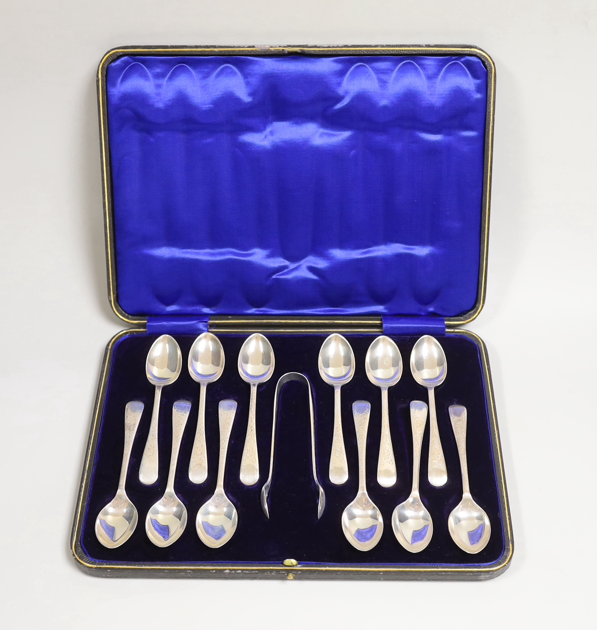 A cased set of twelve George V engraved silver Old English pattern teaspoons and pair of sugar tongs, W.S. Savage & Co, Sheffield, 1914.